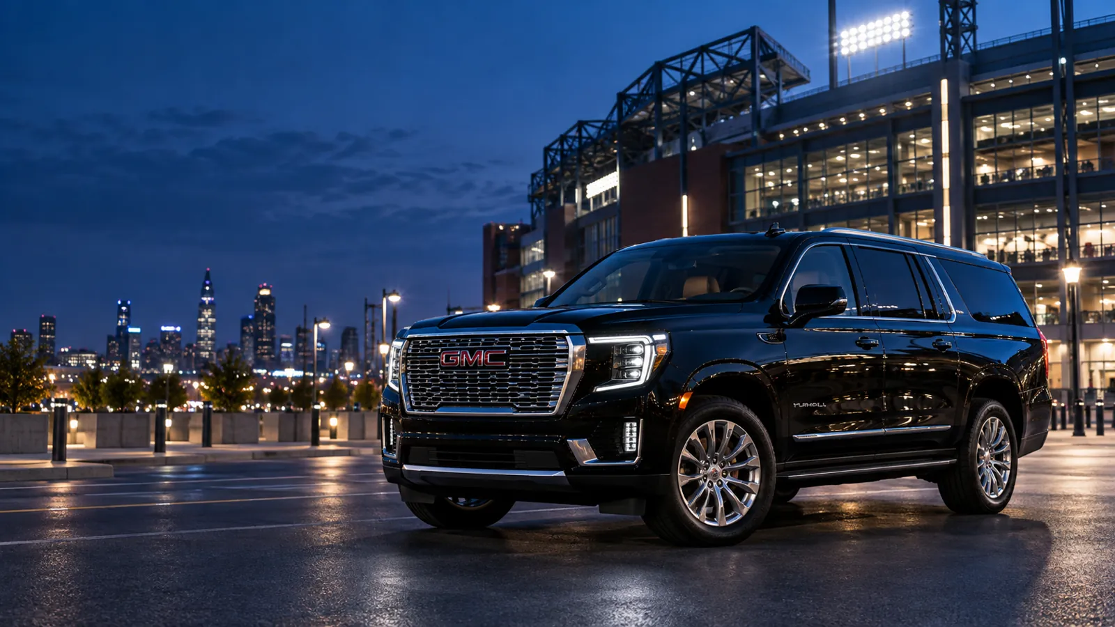 Black full-size SUV parked outside a stadium at night, with a city skyline behind